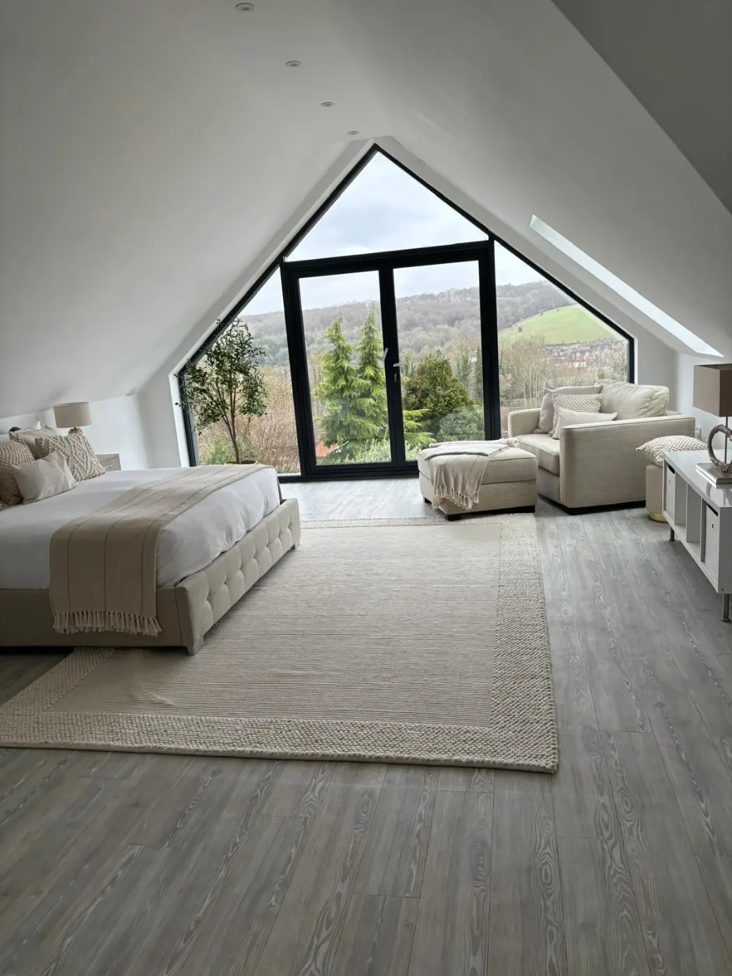 Completed upper-floor bedroom with full-height gable glazing