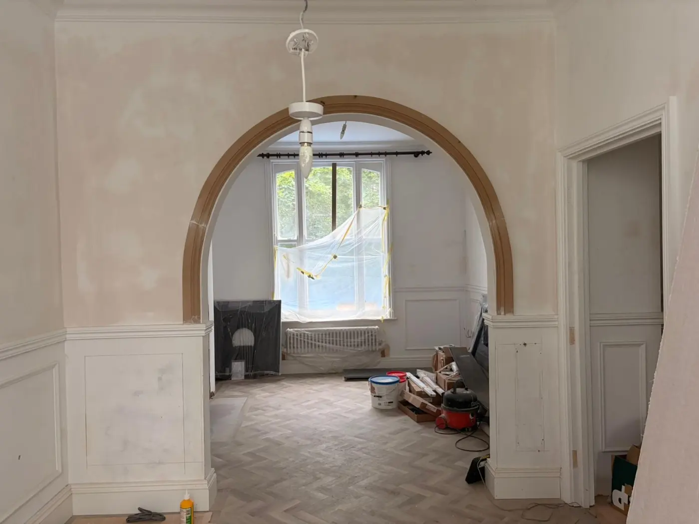 Period room with an original arched opening undergoing careful refurbishment